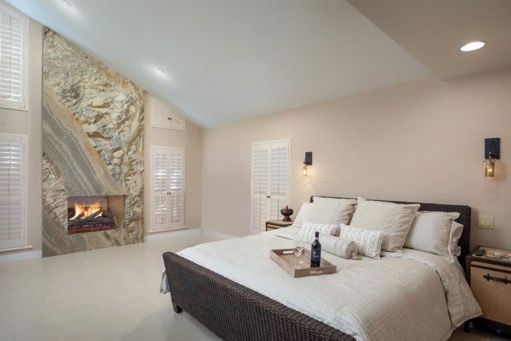 Interior design for master bedroom with vaulted ceilings and gas fireplace.